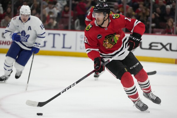 Chicago Blackhawks right wing Taylor Raddysh handles the puck during the first period of an NHL hockey game against the Toronto Maple Leafs, Friday, Nov. 24, 2023, in Chicago. (AP Photo/Erin Hooley)