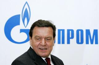 File--- File photo shows Former German Chancellor Gerhard Schroeder walking in Russian natural gas monopoly Gazprom headquarters in Moscow, Thursday, March 30, 2006.  German Chancellor Olaf Scholz is flying to Washington this week on a mission to reassure Americans that his country stands alongside the United States and other NATO partners in opposing any Russian aggression against Ukraine.(AP Photo/ Alexander Zemlianichenko, file )