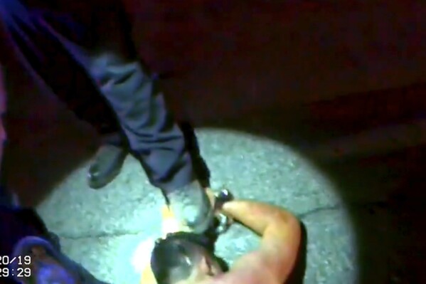 In this image from Hampton Police Department body-camera video, officers restrain Fernando Rodriguez in the middle of a street in Hampton, Ga., on Sept. 20, 2019. A county coroner ruled his death a homicide, resulting from asphyxia due to physical restraint in the prone position with compression of the chest and LSD use. (Hampton Police Department via AP)