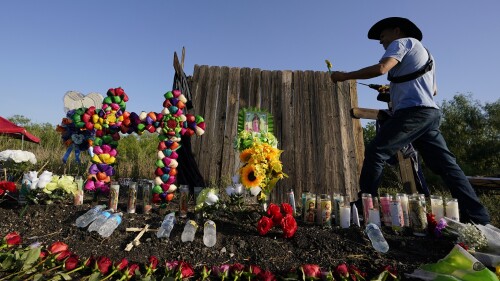 ARCHIVO - Roberto Marquez, de Dallas, coloca una flor el 29 de junio de 2022, en un altar instalado donde las autoridades estadounidenses encontraron a decenas de personas muertas en un camión de carga, en San Antonio, Texas. (AP Foto/Eric Gay, Archivo)