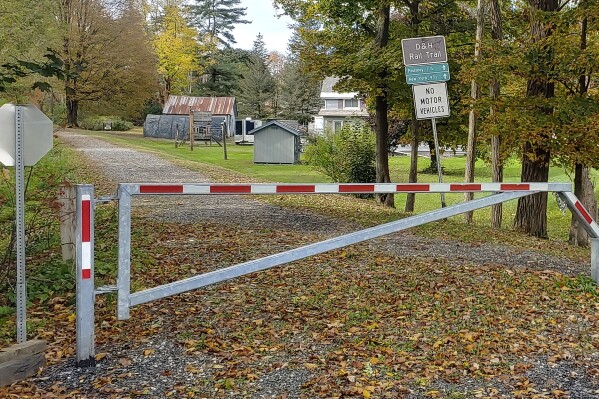 Signs and a closed gate stand at an entrance to the Delaware & Hudson Rail Trail, Monday, Oct. 9, 2023, in Castleton, Vt. Police said an autopsy showed that retired dean and professor Honoree Fleming, of Castleton, Vt., died from a gunshot wound to the head on Thursday, Oct. 5. She was found on the Delaware & Hudson Rail Trail about a mile south of the Castleton campus of Vermont State University, which was closed. (Keith Whitcomb, Jr./The Times Argus via AP)
