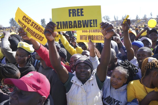 Supporters of Zimbabwe's main opposition leader Nelson Chamisa hold placards upon his arrival for a a rally on the outskirts of Harare on Sunday, July 17, 2023. In an interview with The Associated Press Chamisa gave warning that any evidence of tampering by Mnangagwa's ruling ZANU-PF party in this month's elections could lead to "total disaster" for an already-beleaguered nation. Zimbabwe has a history of violent and disputed votes. (AP Photo/Tsvangirayi Mukwazhi)