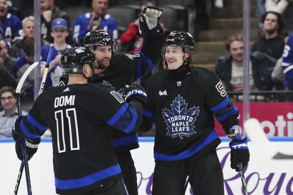 Toronto Maple Leafs left wing Tyler Bertuzzi (59) celebrates his goal against the Washington Capitals with forward Max Domi (11) and defenseman TJ Brodie (78) during the second period of an NHL hockey game Thursday, March 28, 2024, in Toronto. (Nathan Denette/The Canadian Press via AP)