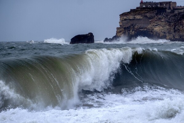 Big waves roll towards the beach of Nazare, Portugal, Wednesday, March 27, 2024. Strong winds caused the high waves in one of the world's most popular surf spots. (AP Photo/Michael Probst)