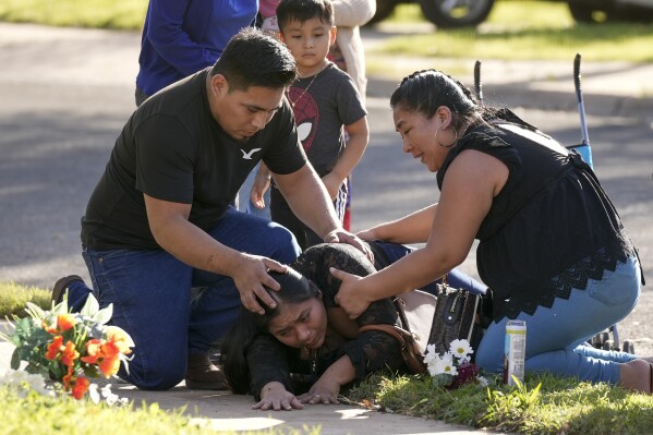 Domatilia Caal, center, is consoled by her brother, Cornelio, and sister Filomena, on Wednesday, Dec. 6, 2023, in Austin, Texas, at the site where her husband was killed in a violent trail of separate attacks on Tuesday. (Jay Janner/Austin American-Statesman via AP)