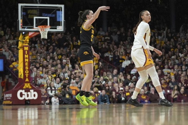 Iowa guard Caitlin Clark, left, gestures after making a 3-point basket during the second half of an NCAA college basketball game against Minnesota, Wednesday, Feb. 28, 2024, in Minneapolis. (AP Photo/Abbie Parr)