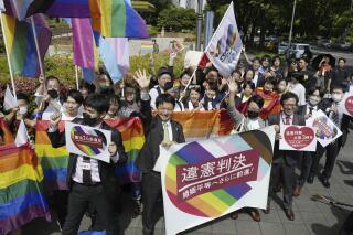 Lawyers of plaintiffs and supporters celebrate following a ruling in front of the Nagoya District Court in Nagoya, central Japan Tuesday, May 30, 2023. The Japanese court on Tuesday found the government policy of not allowing same-sex marriage unconstitutional, a closely-watched ruling that could give a push toward achieving marriage equality in a country that still resists anti-discrimination law for LGBTQ+ rights. A banner, center, reads "unconstitutional judgment." (Kyodo News via AP)