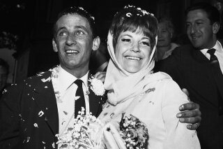 FILE - In this Aug. 19, 1963, file photo, British jazz singer Annie Ross, right, and actor Sean Lynch are covered with confetti after their marriage in London. Ross, who rose to fame as a jazz singer in the 1950s, struggled with personal problems in the '60s, faded from the spotlight in the '70s, re-emerged as a successful character actress in the '80s and finished her career as a cabaret mainstay, died Tuesday, July 21, 2020, at her home in New York. She was 89. Her death was confirmed by her former manager, Jim Coleman. (AP Photo/Dear, File)