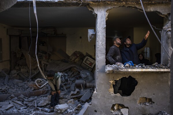 Palestinians look at the destruction after an Israeli strike in Rafah, southern Gaza Strip, Thursday, Feb. 8, 2024. (AP Photo/Fatima Shbair)