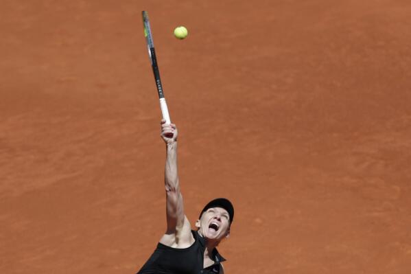 Simona Halep of Romania serves to Elise Mertens of Belgium during their match at the Madrid Open tennis tournament in Madrid, Spain, Tuesday, May 4, 2021. (AP Photo/Paul White)