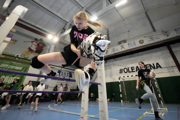 A girl competes during a Hobby horsing competition in St. Petersburg, Russia, on Sunday, April 21, 2024. Several dozen kids, 48 girls and one boy, from first-graders to teenagers gathered in a gymnasium in northern St. Petersburg, Russia's second largest city, for a hobby horsing competition. (AP Photo/Dmitri Lovetsky)