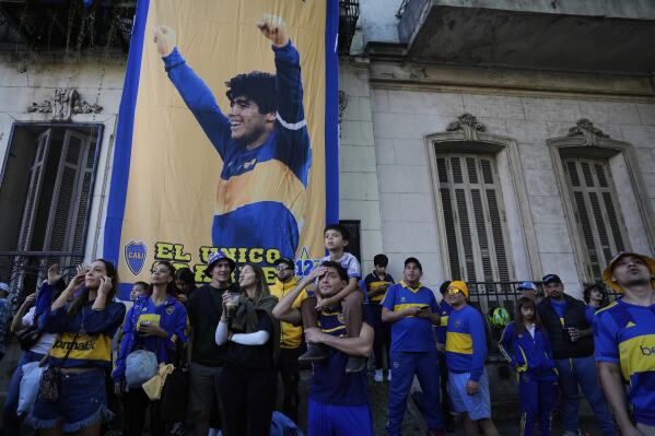 Boca Juniors fans watch their team play a local tournament soccer league match against River Plate, in front of a banner of soccer legend Diego Maradona, in La Boca neigborhood in Buenos Aires, Argentina, Sunday, April 27, 2025. (AP Photo/Natacha Pisarenko)