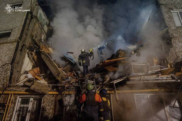 In this photo provided by the Ukrainian Emergency Service on Wednesday, March 13, 2024, emergency services personnel work at an apartment building destroyed by a Russian attack in Sumy, Ukraine. (Ukrainian Emergency Service via AP)