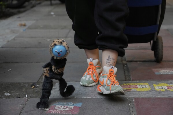 A street vendor displays her puppet on a sidewalk in northern Tehran, Iran, Monday, June 2, 2025. (AP Photo/Vahid Salemi)