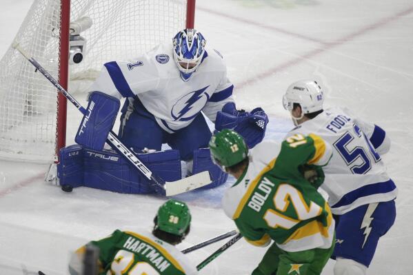 Tampa Bay Lightning goaltender Brian Elliott (1) stops a shot by Minnesota Wild left wing Matt Boldy (12) with defense from Tampa Bay Lightning defenseman Cal Foote in the first period during an NHL hockey game, Wednesday, Jan. 4, 2023, in St. Paul, Minn. (AP Photo/Andy Clayton-King)