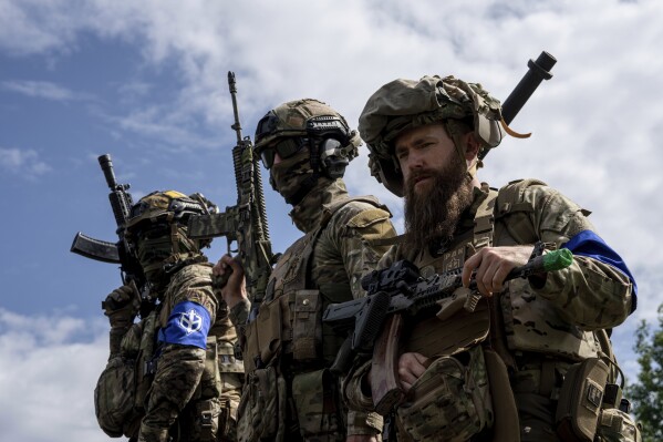 FILE - Fighters of Russian Volunteer Corps stand atop on an APC during press conference not far from the Ukraine's border with Russia in Sumy region, Ukraine, on May 24, 2023. Fighters from Ukraine made an attempt to cross into the town of Tetkino, which lies right on the border, the governor of Russia’s Kursk region, Roman Starovoit, said Tuesday. (AP Photo/Evgeniy Maloletka, File)