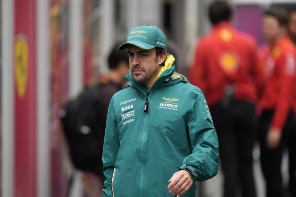 FILE - Aston Martin driver Fernando Alonso of Spain walks in the paddock before the first free practice session at the Suzuka Circuit in Suzuka, central Japan, on April 5, 2024, ahead of Sunday's Japanese Formula One Grand Prix. Two-time Formula One champion Fernando Alonso has signed a contract extension to remain at Aston Martin for at least the next two seasons. The 42-year-old Spaniard is in his second season at Aston Martin which announced the extension on Thursday as a “multiyear” deal. (AP Photo/Hiro Komae, File)