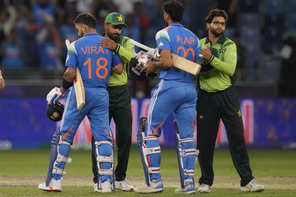 Pakistan's Babar Azam, second left, and Imam-ul Haq, right, greets India's Virat Kohli, left, and Axar Patel, second right, after India won the ICC Champions Trophy cricket match against Pakistan at Dubai International Cricket Stadium, United Arab Emirates, Sunday, Feb. 23, 2025. (AP Photo/Altaf Qadri)