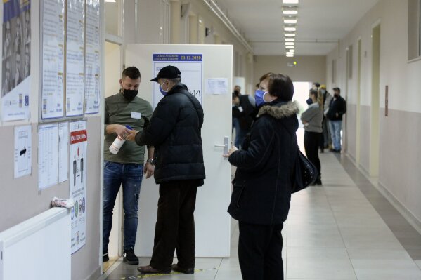 Voters arrive at a polling station in Mostar, Bosnia, Sunday, Dec. 20, 2020. Divided between Muslim Bosniaks and Catholic Croats, who fought fiercely for control over the city during the 1990s conflict, Mostar has not held a local poll since 2008, when Bosnia's constitutional court declared its election rules to be discriminatory and ordered that they be changed. (AP Photo/Kemal Softic)