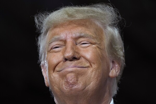 FILE - Former President Donald Trump speaks during a commit to caucus rally, Oct. 16, 2023, in Adel, Iowa. Trump is crushing his Republican presidential rivals in the contest to raise campaign cash, putting the other White House hopefuls in an unenviable position before the first votes are cast in January. (AP Photo/Charlie Neibergall)