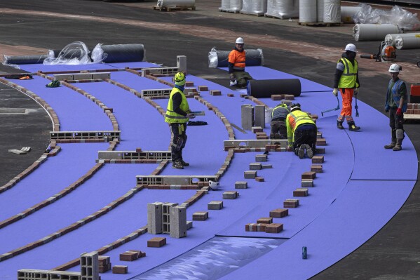 The purple athletics track at the Olympic Stadium, currently known as Stade de France, is being installed, in Saint-Denis, north of Paris, Tuesday, April 9, 2024. The Olympic Stadium will host the athletics events at the Paris 2024 Olympic Games. (AP Photo/Aurelien Morissard)