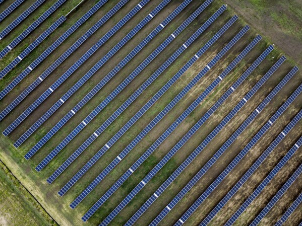 FILE - Solar panels are visible at the Michichi Solar project near Drumheller, Alberta, July 11, 2023. The window to limit human-caused warming to a globally agreed goal is narrowing but still open because of the huge growth of solar energy and electric vehicles sales worldwide, a report said Tuesday, Sept. 26. (Jeff McIntosh/The Canadian Press via AP)