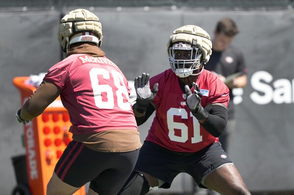 San Francisco 49ers' Chris Hubbard (61) and Colton McKivitz (68) takes part in drills during NFL football practice in Santa Clara, Calif., Tuesday, June 4, 2024. (AP Photo/Tony Avelar)