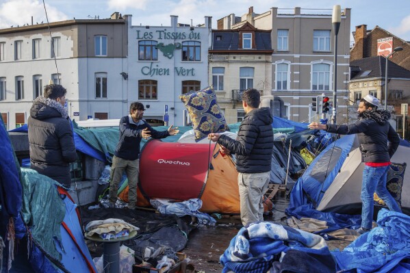 FILE - Men organize their belongings at a makeshift tent camp outside the Petit Chateau reception center in Brussels, on Jan. 17, 2023. The Belgian government said Wednesday Aug. 30, 2023 it is imposing a ban on providing shelter for single men seeking asylum, arguing its insufficient reception capacity should be freed for families, women and children first. Aid organizations condemned the move as reneging on international commitments. (AP Photo/Olivier Matthys, File)