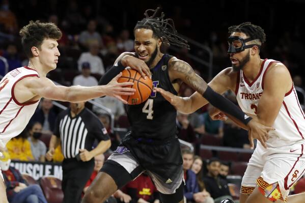 Washington guard PJ Fuller, center, drives between Southern California guard Drew Peterson, left, and forward Isaiah Mobley during the first half of an NCAA college basketball game in Los Angeles, Thursday, Feb. 17, 2022. (AP Photo/Alex Gallardo)
