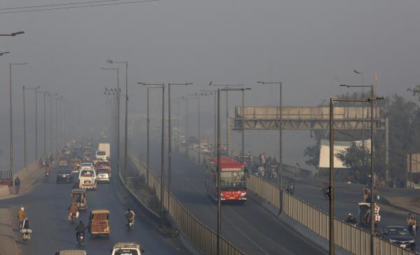 Vehicles drive along a highway as smog envelops the area of Lahore, Pakistan, Monday, Nov. 22, 2021. People of Lahore and adjacent area are suffering from respiratory problems because of poor air quality related to thick smog hanging over the region. (AP Photo/K.M. Chaudary)