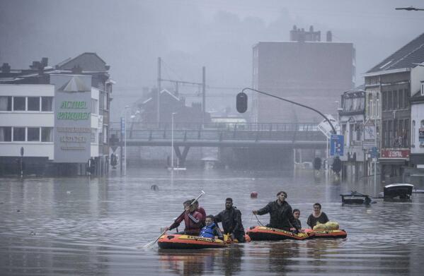 People use rubber rafts in floodwaters after the Meuse River broke its banks during heavy flooding in Liege, Belgium, Thursday, July 15, 2021. Heavy rainfall is causing flooding in several provinces in Belgium with rain expected to last until Friday. (AP Photo/Valentin Bianchi)