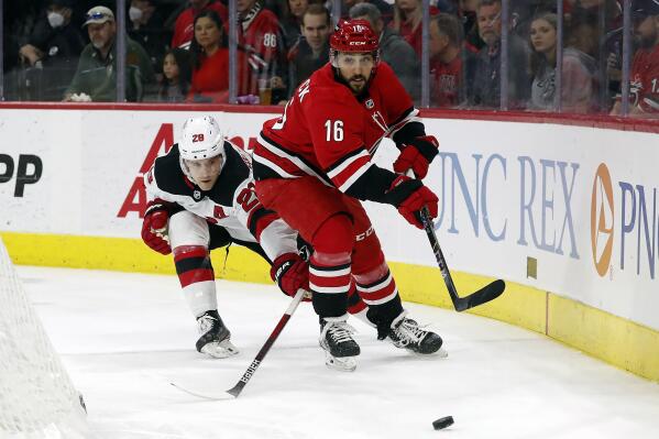Carolina Hurricanes' Vincent Trocheck (16) clears the puck away from New Jersey Devils' Damon Severson (28) during the second period of an NHL hockey game in Raleigh, N.C., Thursday, April 28, 2022. (AP Photo/Karl B DeBlaker)