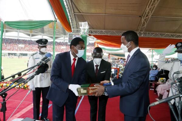 Zambian outgoing President Edgar Chagwa Lungu, right, hands over the instruments of power to his successor, President Hakainde Hichilema during his inauguration ceremony at Heroes Stadium in Lusaka, Zambia, Tuesday, Aug. 24, 2021. Zambia’s new president, longtime opposition leader Hakainde Hichilema, has been sworn into power on Tuesday, raising hopes in the southern African country that in recent years has swung from prosperity and stability to massive debt, recession and repression. Hichilema told a cheering crowd that he would deliver a “united, prosperous and equitable Zambia.” (AP Photo)