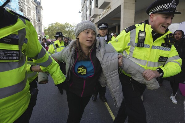 Environmental activist Greta Thunberg ais taken away by police officers during the Oily Money Out protest outside the Intercontinental Hostel, in London, Tuesday, Oct. 17, 2023. (AP Photo/Kin Cheung)
