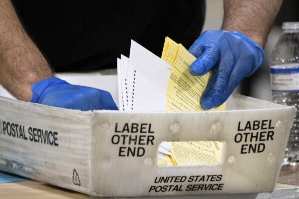 FILE - In this Jan. 5, 2021 file photo, Fulton County, Georgia, elections workers process absentee ballots for a U.S. Senate runoff election in Atlanta. Georgia's state House voted on Wednesday, Jan. 31, 2024, to require watermarks on ballots, with the bill moving on to the state Senate for more debate. (AP Photo/Ben Gray, File)