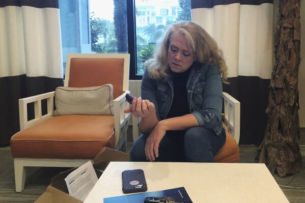 
              In this Nov. 1, 2018 photo, Polly Varnado looks at her daughter's Medtronic insulin pump in Destin, Fla. Medical device manufacturers and experts say insulin pumps are safe. But an AP investigation found that insulin pumps and their components are responsible for the highest number of malfunction, injury and death reports in the U.S. Food and Drug Administration’s medical device database.  (AP Photo/Holbrook Mohr)
            