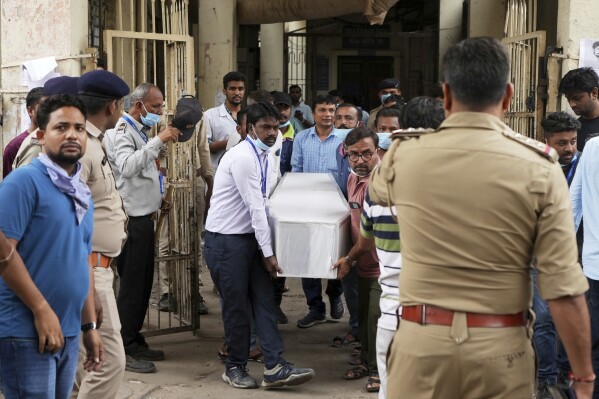 Healthcare workers and volunteers will carry the bodies of the victims of a plane crashed in Ahmedabad city in northwestern India in Gujarat on Friday, June 13th, 2025.