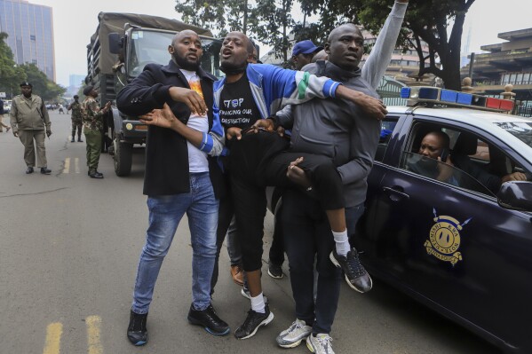 A protester is detained by plain-clothes security forces during a demonstration against the Finance Bill, in downtown Nairobi, Kenya Thursday, June 15, 2023. Kenyans are preparing for tough times after lawmakers late Wednesday, June 21, 2023 approved tax increases that are even unpopular with supporters of the president who once vowed to reduce the cost of living. (AP Photo)