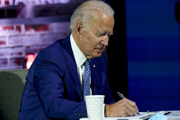 President-elect Joe Biden takes notes during a meeting with his COVID-19 advisory council, Monday, Nov. 9, 2020, at The Queen theater in Wilmington, Del. (AP Photo/Carolyn Kaster)
