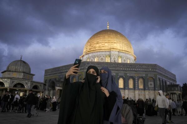 Palestinians attend Eid al-Fitr holiday celebrations by the Dome of the Rock shrine in the Al Aqsa Mosque compound in Jerusalem's Old City, Friday, April 21, 2023. The holiday marks the end of the holy month of Ramadan, when devout Muslims fast from sunrise to sunset. (AP Photo/Mahmoud Illean)