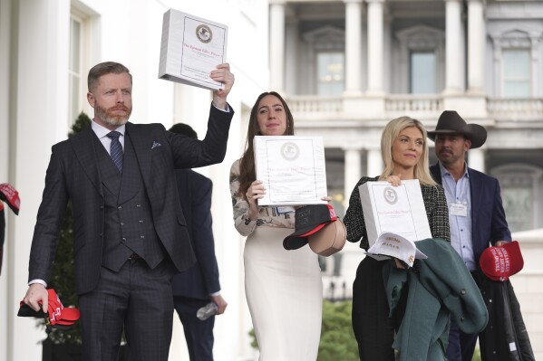 El comentarista político conservador Rogan O'Handley, también conocido como DC Draino, de izquierda a derecha, la creadora de contenido para redes sociales Chaya Raichik y la comentarista política conservadora Liz Wheeler sostienen carpetas con una portada titulada "Los archivos de Epstein: Fase 1", junto a Jack Posobiec en la Casa Blanca, el jueves 27 de febrero de 2025, en Washington. (Foto AP/Evan Vucci)