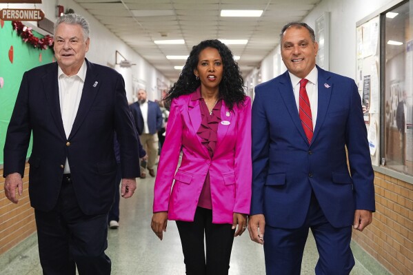 CORRECTS LAST NAME TO PILIP, NOT PHILIP - Mazi Pilip, center, the Republican congressional candidate for New York's 3rd district, arrives to vote early at a polling station in Massapequa, N.Y., Friday, Feb. 9, 2024. The race to replace disgraced former Rep. George Santos pits Pilip, a Nassau County legislator, against former U.S. Rep. Tom Suozzi, a Democrat who represented the district for three terms before quitting to run for governor. Joining Pilip are, former U.S Rep. Peter King, left, and Oyster Bay, N.Y., Town Supervisor Joseph Saladino. (Adam Gray/Pool Photo via AP)