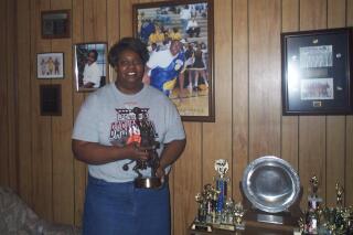 FILE - Lusia Harris Stewart shows off some of her medals and awards from her basketball career, Jan. 10, 2002, in her home in Greenwood, Miss. Harris, who was the only woman to be drafted by an NBA team and scored the first points in women's basketball history at the Olympics, died Tuesday, Jan. 18, 2022, her family announced. She was 66. (Tony Krausz/The Delta Democrat-Times via AP, File)