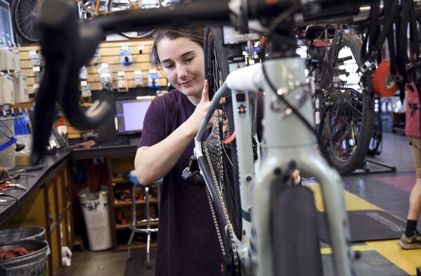 Mechanic Lizzy Thomson works at University Bicycles in Boulder, Colo., Tuesday, April 30, 2024. Bike stores quickly sold out of their stock early in the pandemic and had trouble restocking because of supply chain issues. Now, inventory is back, but demand has waned. (AP Photo/Thomas Peipert)