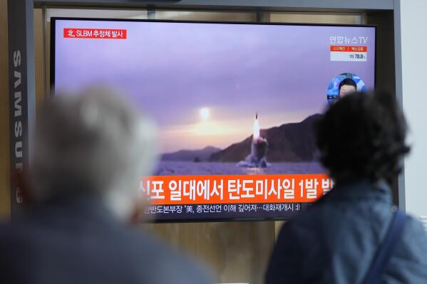 People watch a TV screen showing a news program reporting about North Korea's missile launch with file footage at a train station in Seoul, South Korea, Tuesday, Oct. 19, 2021. North Korea fired a ballistic missile into the sea on Tuesday in a continuation of its recent weapons tests, the South Korean and Japanese militaries said, hours after the U.S. reaffirmed its offer to resume diplomacy on the North's nuclear weapons program. A part of Korean letters reads: "Fired a ballistic missile." (AP Photo/Lee Jin-man)