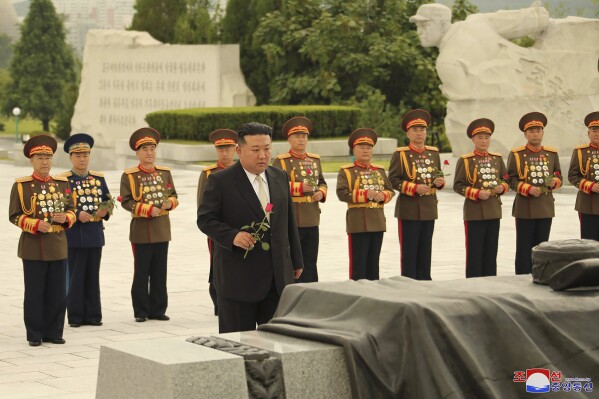 In this photo provided by the North Korean government, North Korean leader Kim Jong Un, foreground, prepares to offer a flower at a liberation war martyrs cemetery in Pyongyang, North Korea Tuesday, July 25, 2023, on the occasion of the 70th anniversary of the armistice that halted fighting in the 1950-53 Korean War. Independent journalists were not given access to cover the event depicted in this image distributed by the North Korean government. The content of this image is as provided and cannot be independently verified. Korean language watermark on image as provided by source reads: 