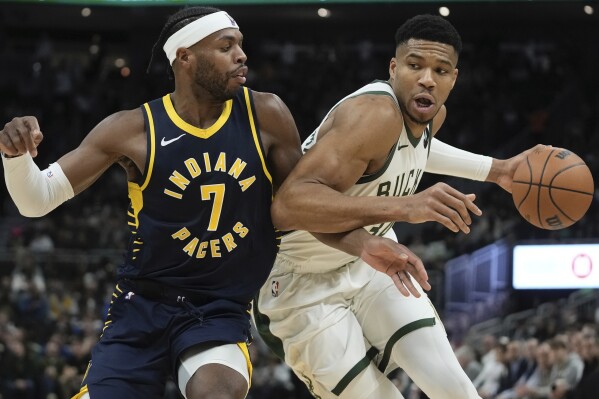 Milwaukee Bucks' Giannis Antetokounmpo drives by Indiana Pacers' Buddy Hield during the first half of an NBA basketball game Wednesday, Dec. 13, 2023, in Milwaukee. (AP Photo/Morry Gash)
