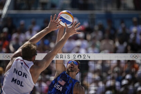 US' Miles Evans hits the ball during the men's round of 16 beach volleyball match between USA and Norway at Eiffel Tower Stadium at the 2024 Summer Olympics, Monday, Aug. 5, 2024, in Paris, France. (AP Photo/Louise Delmotte)