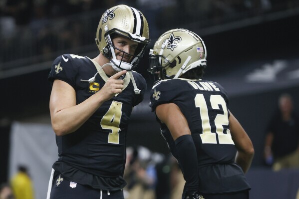 New Orleans Saints quarterback Derek Carr (4) celebrates the team's touchdown with wide receiver Chris Olave (12) in the second half of an NFL football game against the Tennessee Titans in New Orleans, Sunday, Sept. 10, 2023. (AP Photo/Butch Dill)