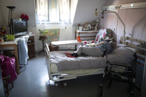 A resident rests on her bed at a nursing home in Kaysesberg, France Thursday April 16, 2020. (AP Photo/Jean-Francois Badias)